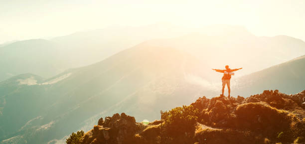 istock High Mountain hiker with backpack tiny figurine stands on mountain peak 1156910497