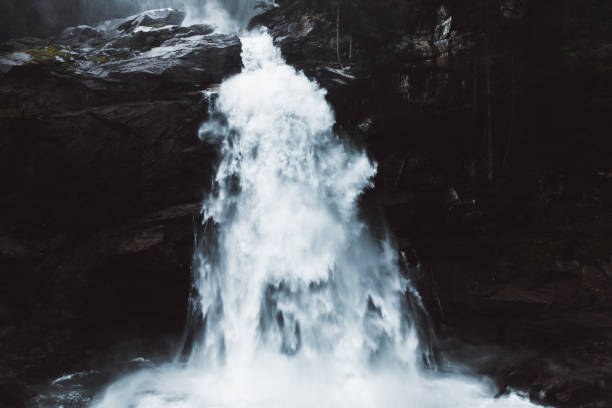 Dramatic view of one of the highest waterfalls in Europe during foggy summer day in Tyrol - the Alps