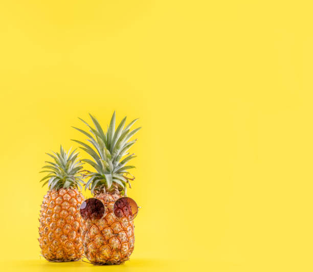 istock Creative pineapples with sunglasses isolated on yellow background, summer vacation beach idea design pattern, copy space, close up, blank for text 1156911098