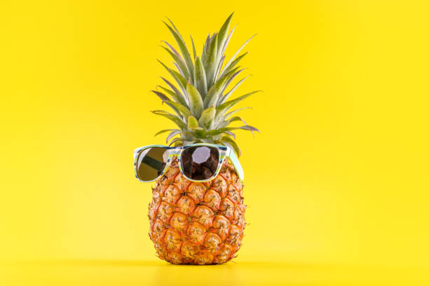 istock Creative pineapples with sunglasses isolated on yellow background, summer vacation beach idea design pattern, copy space, close up, blank for text 1156911216