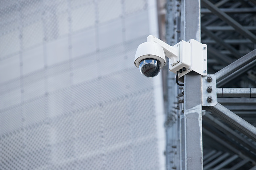 Vista de una cámara de video de vigilancia contemporánea unida a una viga metálica de la fachada de un rascacielos de negocios moderno; cámara de vídeo de seguridad en la fachada de una oficina de gran altura photo