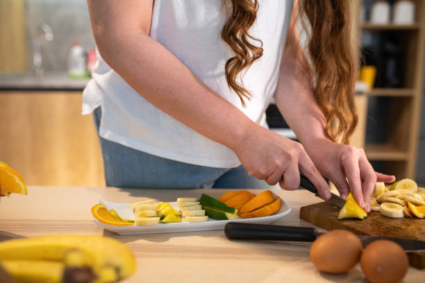 istock Woman preparing a fruit salad 1156912220