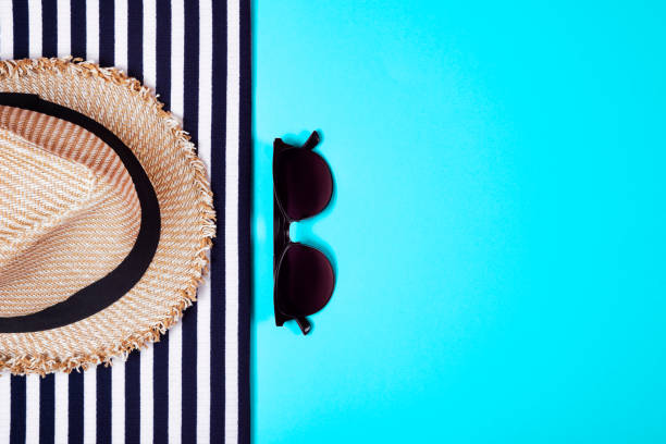 istock Striped clothes, sunglasses and straw hat on turquoise. Top view. Flat lay. 1156912385