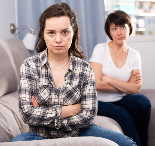 istock Young female and her elderly sister sitting at sofa during quarrel 1156915034