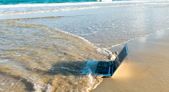 Sea water washing away a laptop.