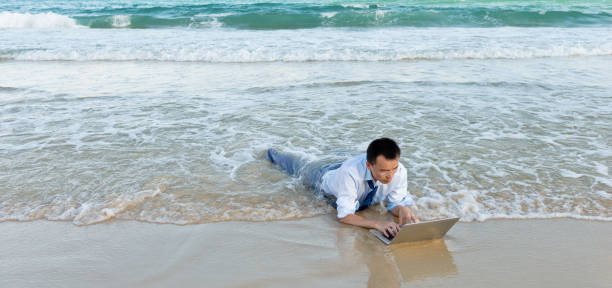 giovane uomo d'affari su una spiaggia con un laptop - china sea foto e immagini stock