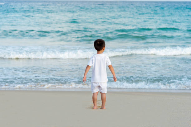 Little boy at the beach, arms outstretched