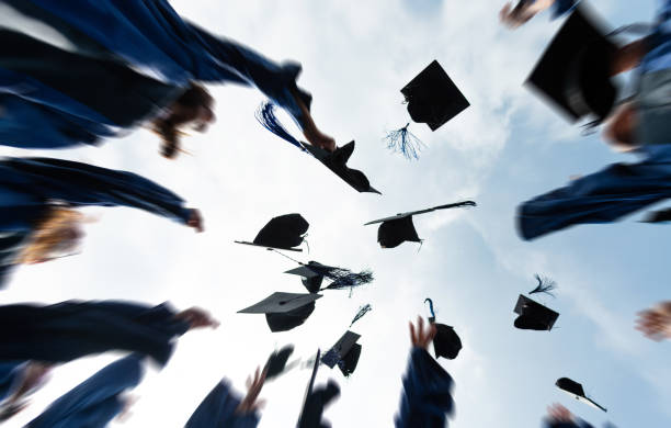 Group of graduate students throwing graduation hats to the sky Group of graduate students throwing graduation hats to the sky. graduation throwing cap stock pictures, royalty-free photos & images