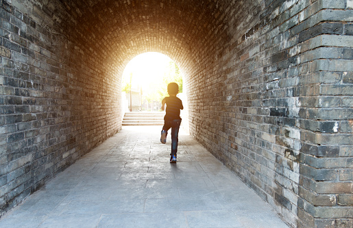 Little boy running through the tunnel