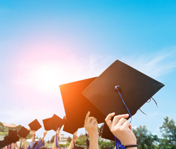 istock Group of graduate students holding their graduation hats 1156917536