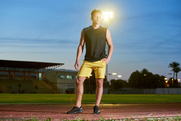 Young muscular man posing on a stadium track