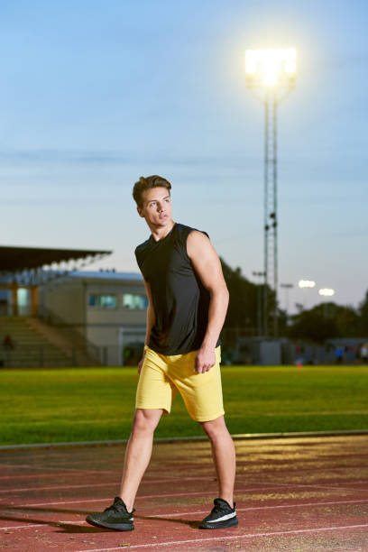 istock Young muscular man posing on a stadium track 1156921491