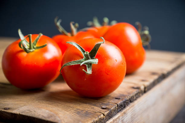 istock Freshly harvested tomatoes on the wooden table 1156921519