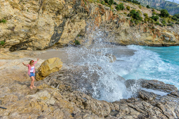Woman very happy getting wet from the waves.