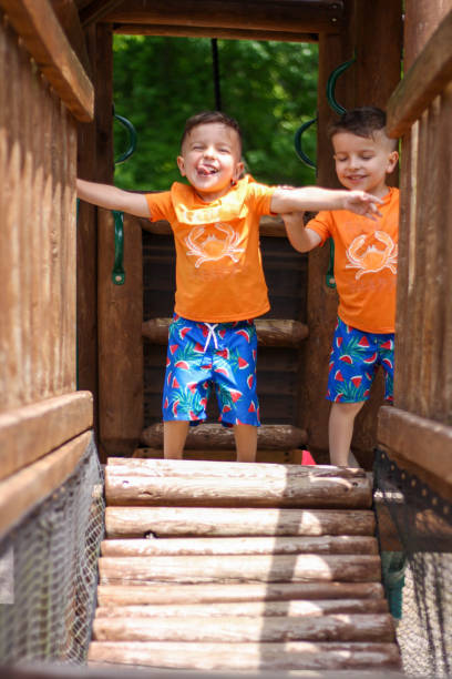 istock Twin boys playing on playground bridge 1156924825