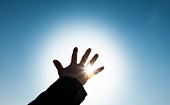 Woman hand trying to reach the sun
