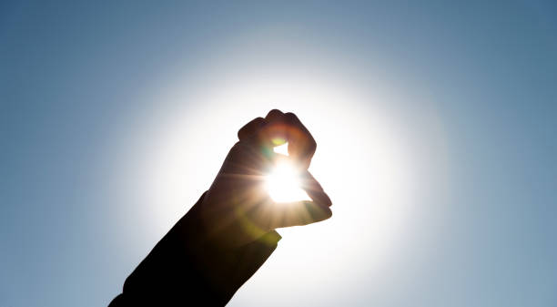 istock Woman's hand gripping the sun 1156925002