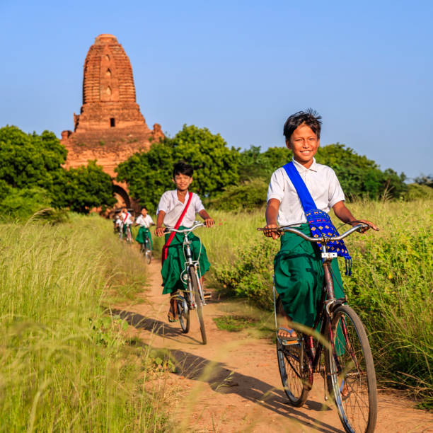 Burmese school children riding a bicycle in Bagan, Myanmar