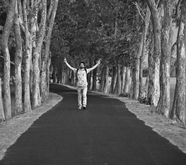 istock Man raising two hands walking in the street 1156926170