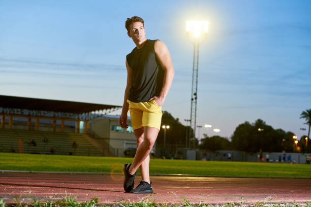 istock Young muscular man posing on a stadium track 1156926860