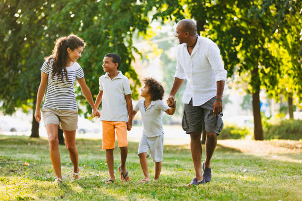 istock Happy couple spending time with their sons in the park 1156928152
