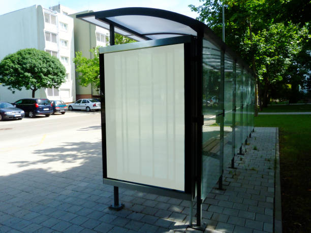 image collage of bus shelter with light poster ad side display image collage of bus shelter. glass & aluminum frame structure design in park-like setting with green background. soft light white green poster ad side display. advertising concept. selective focus. focus at the back bus shelter stock pictures, royalty-free photos & images