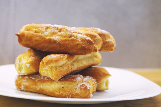 istock eclairs cakes lie on a white plate.  sweet cakes eclairs 1156930830