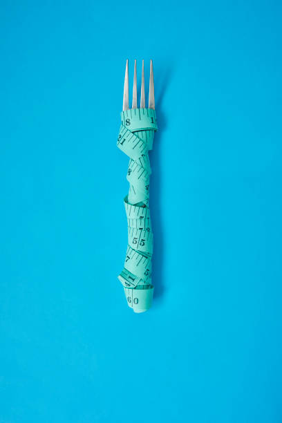 richtig essen, richtig leben - healthy eating fork tape measure still life stock-fotos und bilder