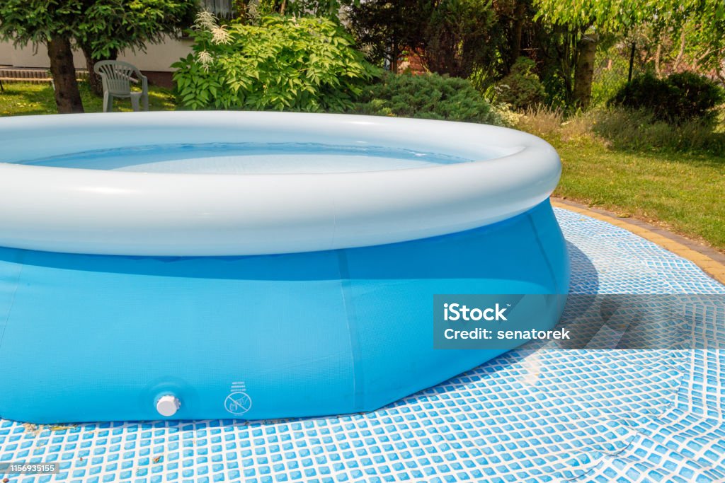 A round, blue, garden pool for children. The pool as a playground for children. Swimming Pool Stock Photo