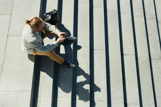 istock Stylish businessman sitting on stairs 1156935937