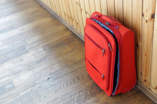 istock Red half-open new suitcase on the wooden background 1156937603