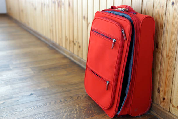 istock Red half-open new suitcase on the wooden background 1156938219