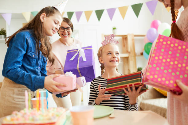 niños dando regalos de cumpleaños - adulation little boys group of people teenage girls fotografías e imágenes de stock