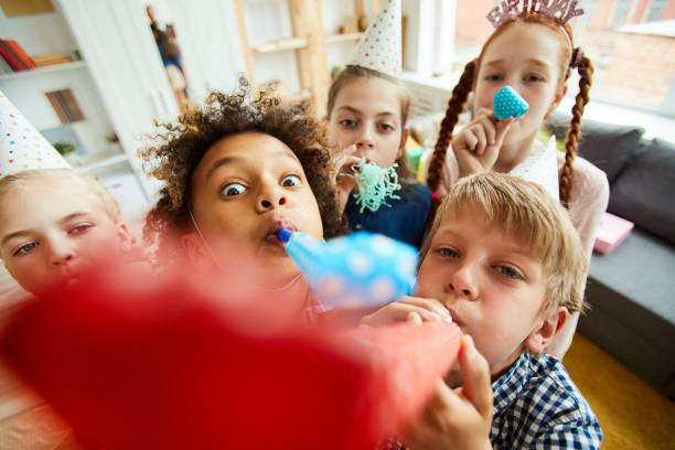 istock Kids Blowing Party Horns 1156938997