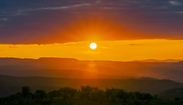 istock Sunset in the mountains over town in the valley 1156940617