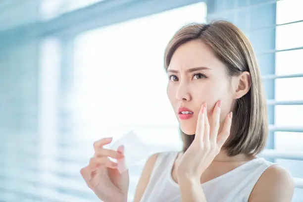 Photo of woman use oil blotting paper