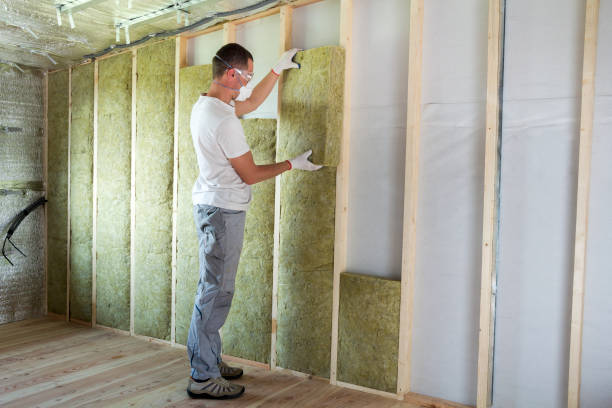 istock Worker in protective goggles and respirator insulating rock wool insulation in wooden frame for future house walls for cold barrier. Comfortable warm home, economy, construction and renovation concept 1156942451