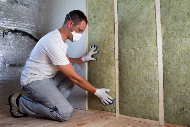 istock Worker in protective goggles and respirator insulating rock wool insulation in wooden frame for future house walls for cold barrier. Comfortable warm home, economy, construction and renovation concept 1156942464