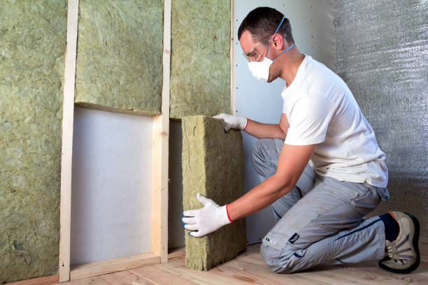 istock Worker in protective goggles and respirator insulating rock wool insulation in wooden frame for future house walls for cold barrier. Comfortable warm home, economy, construction and renovation concept 1156942551