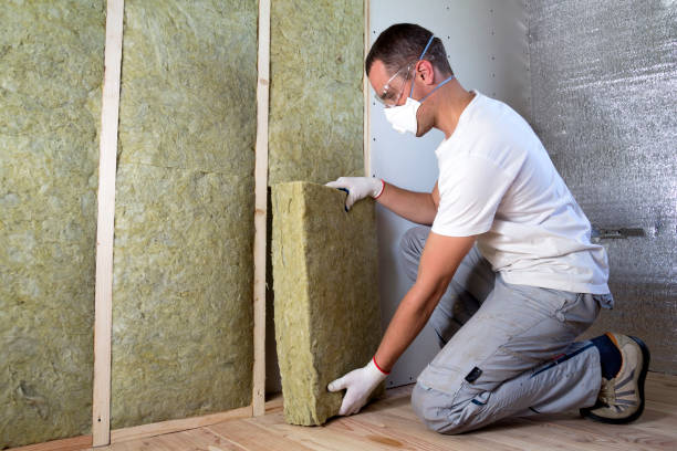 istock Worker in protective goggles and respirator insulating rock wool insulation in wooden frame for future house walls for cold barrier. Comfortable warm home, economy, construction and renovation concept 1156942553