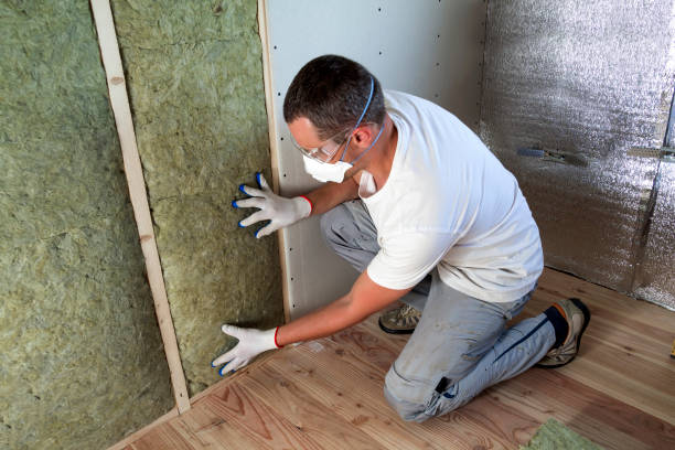 istock Worker in protective goggles and respirator insulating rock wool insulation in wooden frame for future house walls for cold barrier. Comfortable warm home, economy, construction and renovation concept 1156942564
