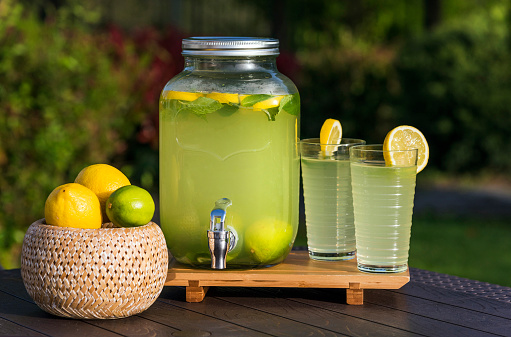 Lemonade prepared with lemon slices in a glass dispenser.