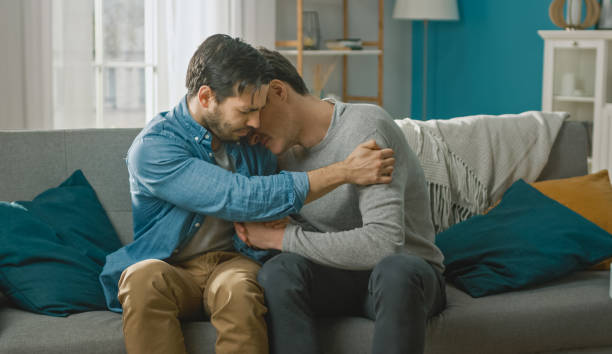 Sad Queer Drama Concept. Boyfriend is Unhappy and Depressed About Something. His Gay Friend is Comforting Him, Holding His Hands. Miserable Man Puts His Head on a Shoulder and Cries. Sad Queer Drama Concept. Boyfriend is Unhappy and Depressed About Something. His Gay Friend is Comforting Him, Holding His Hands. Miserable Man Puts His Head on a Shoulder and Cries. sad gay stock pictures, royalty-free photos & images