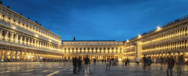 Venice, St. Mark's Square at night (blue hour time) St. Mark's Square (Piazza San Marco) in Venice, Italy,  at night with blurred people in background. gondola traditional boat stock pictures, royalty-free photos & images