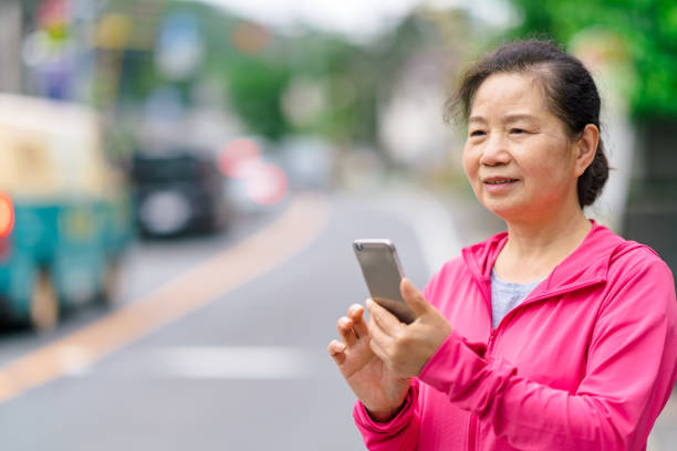 istock Senior woman using smart phone in city 1156952457