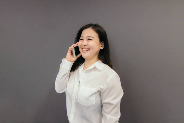 istock Asian Female Talking on a Smart Phone at Work 1156953670