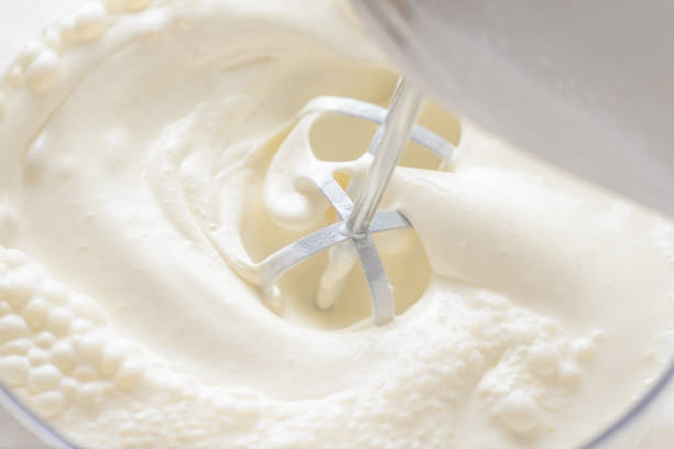 istock Whipping cream with a mixer. Bubbles on cream 1156953727