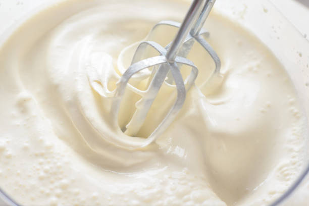 istock Whipping cream with a mixer. Bubbles on cream 1156953733
