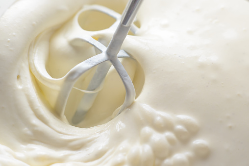 istock Whipping cream with a mixer. Bubbles on cream 1156953755