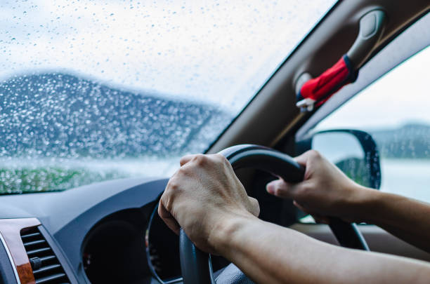 el hombre está conduciendo un coche con atención y cuidado en el mal tiempo día de la temporada de lluvias. - slow jam fotografías e imágenes de stock